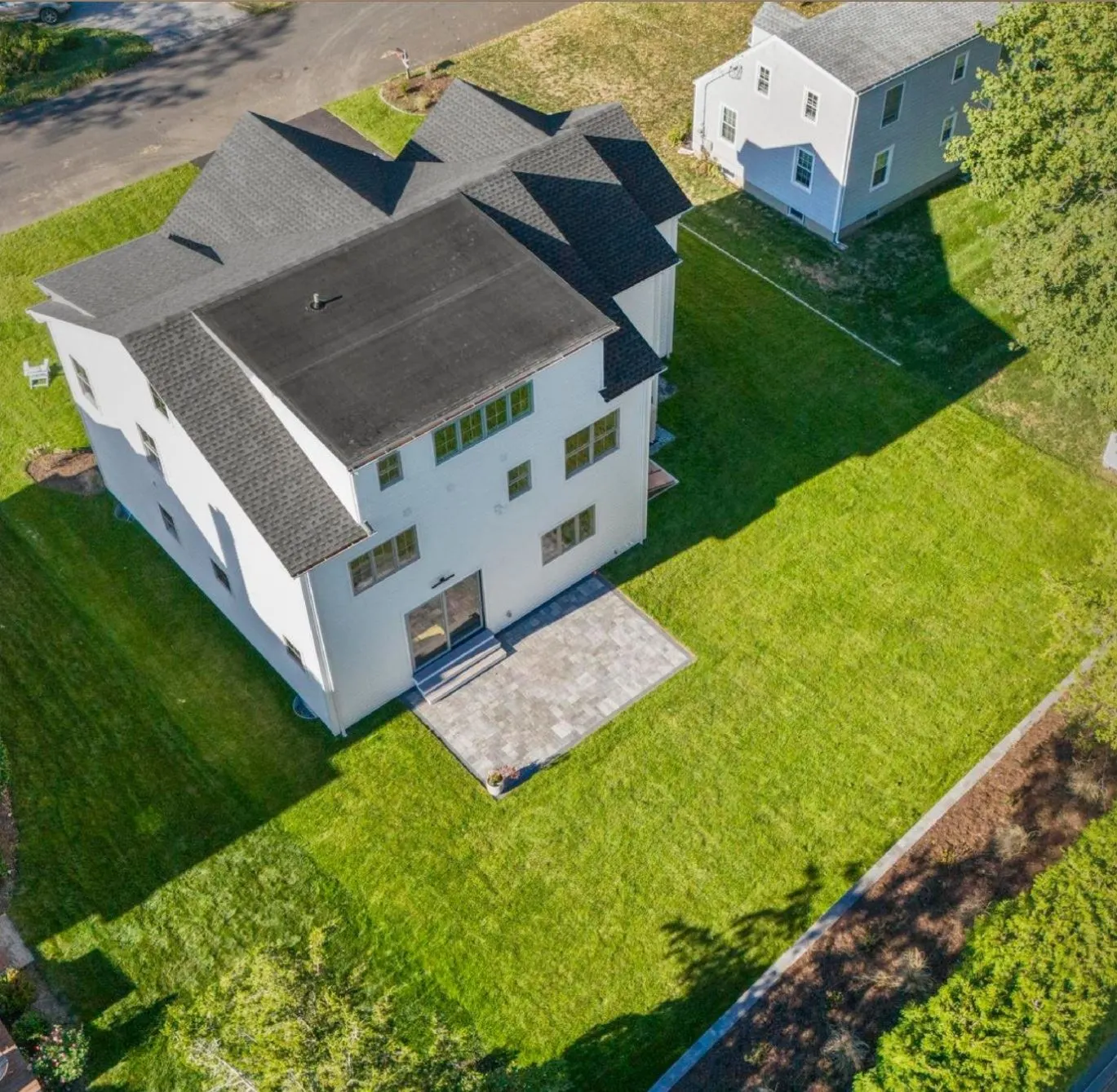 Aerial view of a new white home and backyard
